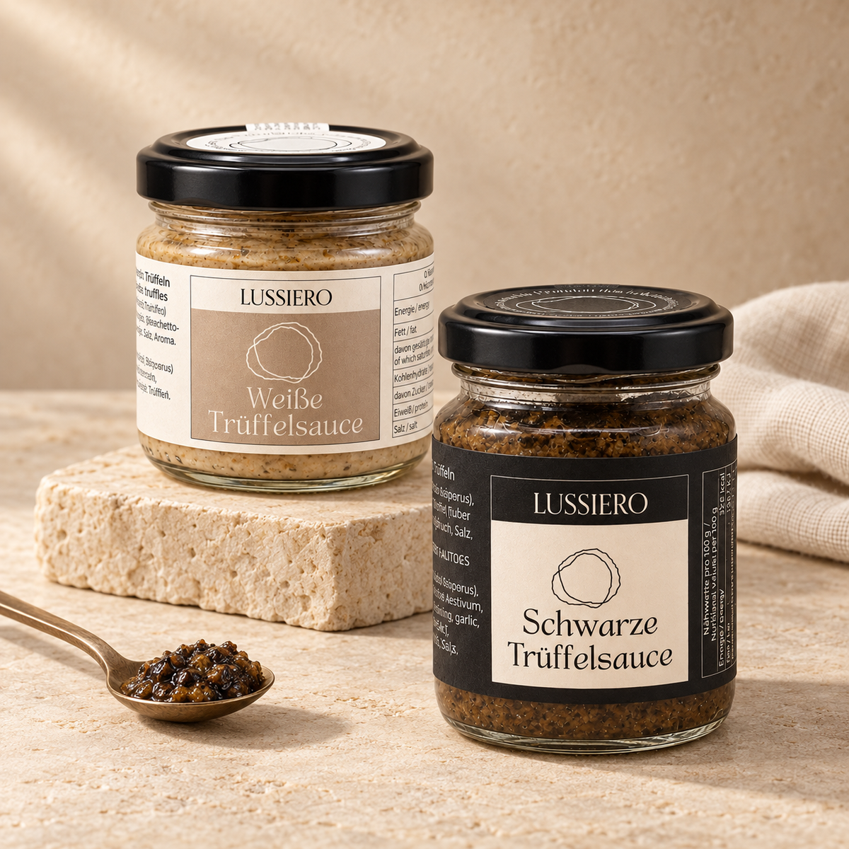 Lussiero Weiße und Schwarze Trüffelsauce im Glas mit einem Löffel Sauce auf hellem Stein