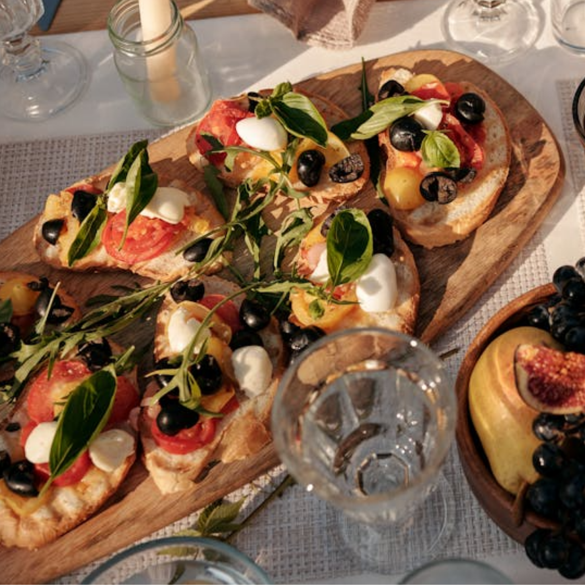 Bruschetta mit Tomaten, Oliven und Feigen auf einem Holzbrett